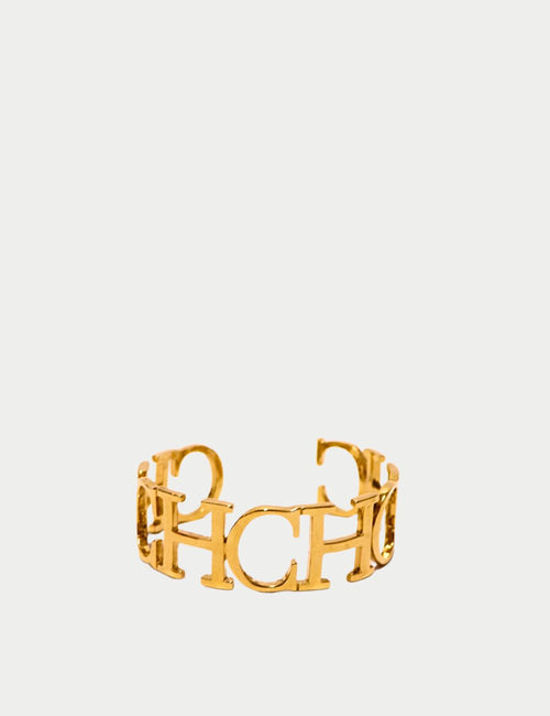 Carolina Herrera gold-plated CH logo cuff bracelet with openwork monogram design, luxury designer jewelry piece.