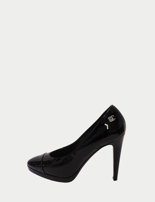 Chanel black patent leather platform pumps with pointed toe, high stiletto heel, and silver-tone logo detail at the back