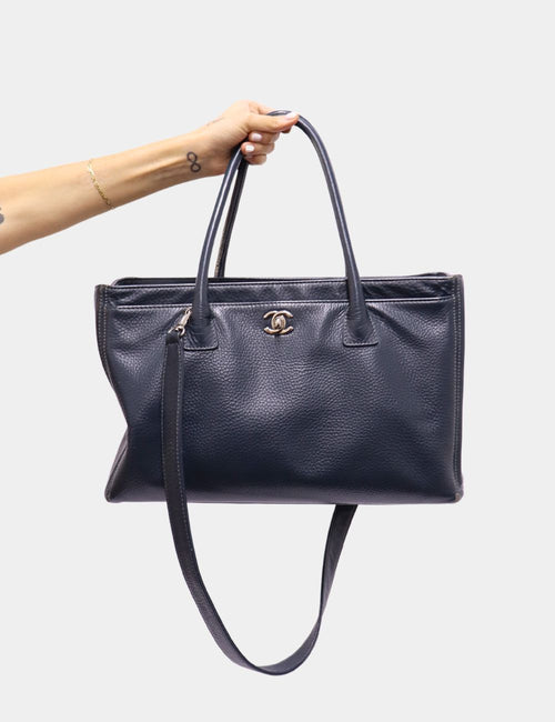 Chanel black caviar leather tote bag with silver-tone CC logo, dual handles, and detachable shoulder strap.
