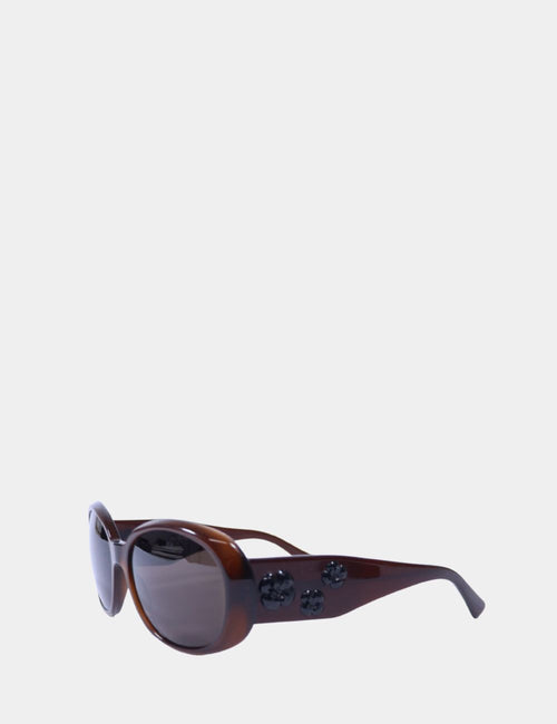 Chanel brown oval sunglasses with black camellia flower embellishments on temples