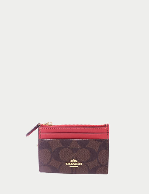 Coach brown signature canvas and red leather zip card case with gold-tone logo and top zip closure.