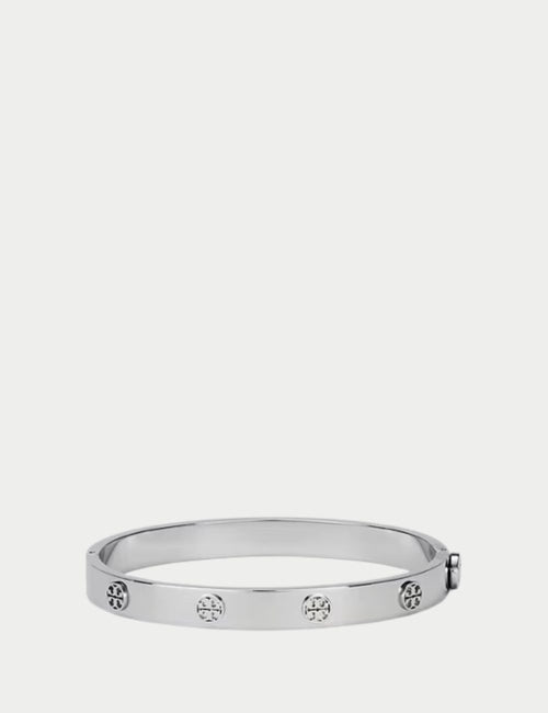 Tory Burch silver-tone hinged bangle bracelet with engraved double-T logo design.