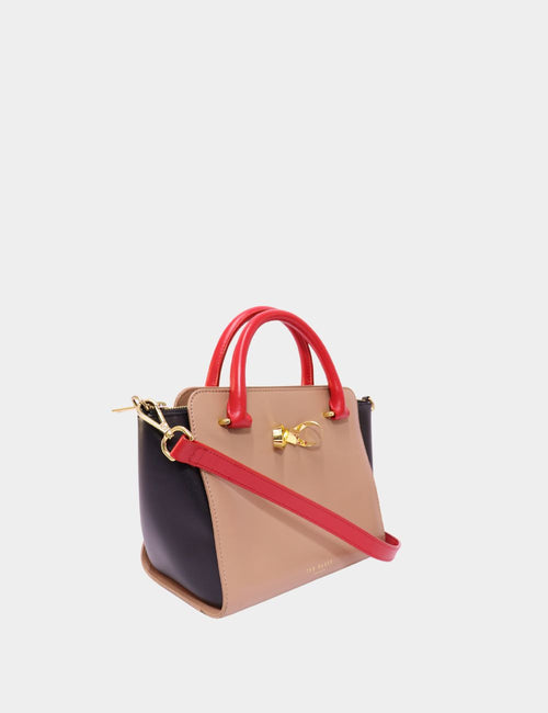 Ted Baker color block mini tote bag with red handles, nude body, black sides, and gold bow detail