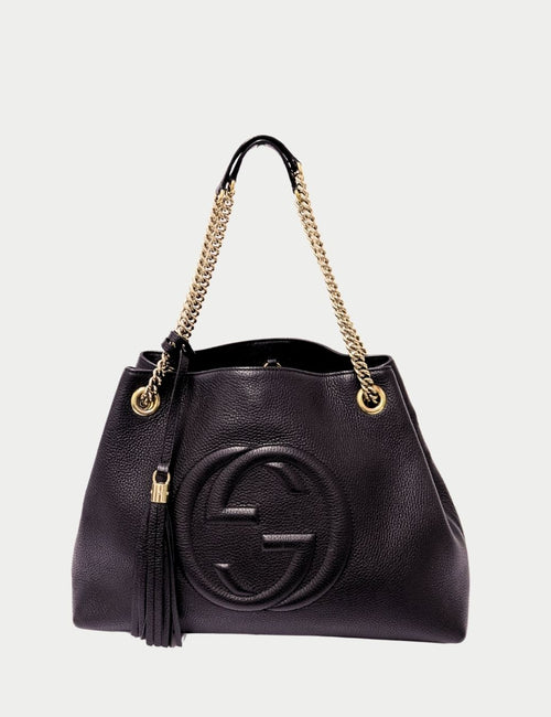 Gucci Soho black pebbled leather shoulder bag with gold chain strap, embossed GG logo, and tassel detail