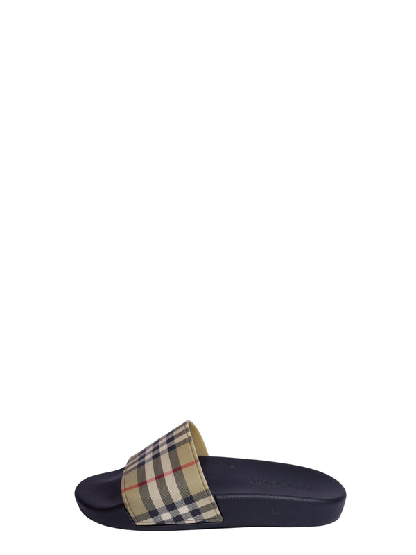 Burberry navy rubber slide sandal featuring the iconic beige Vintage Check strap and slip-on design.