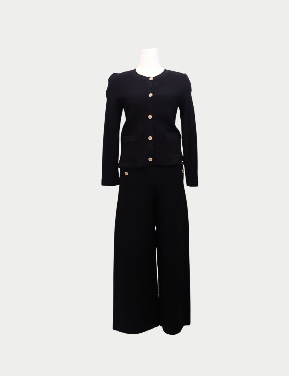 Sophisticated and timeless, this Carolina Herrera two-piece set is crafted in black knit fabric for an effortlessly polished look. The set includes a fitted cardigan-style top with round neckline, long sleeves, front pockets, and gold button detailing, pa Sophisticated and timeless, this Carolina Herrera two-piece set is crafted in black knit fabric for an effortlessly polished look. The set includes a fitted cardigan-style top with round neckline, long sleeves, front pockets, and gold button detailing, pa