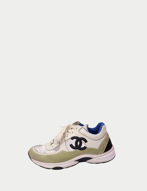 Chanel lace-up sneakers in ivory leather with metallic silver panels, green suede trim, black interlocking CC logo, and blue lining