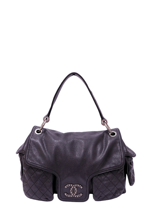 Chanel Coco Rider Multi-Pocket Flap Bag in black caviar leather featuring a single rolled top handle, silver-tone CC hardware, and quilted exterior flap pockets.