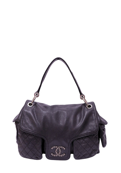 Chanel Coco Rider Multi-Pocket Flap Bag in black caviar leather featuring a single rolled top handle, silver-tone CC hardware, and quilted exterior flap pockets.