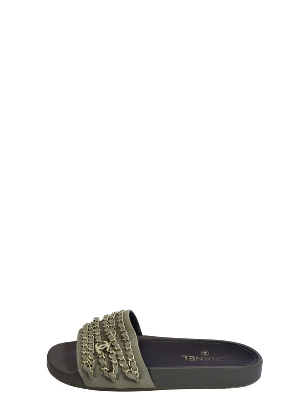 Authentic Chanel khaki green slide sandals featuring wide fabric straps adorned with signature gold-tone chain embellishments, iconic CC logo hardware, and a comfortable slip-on flat design.