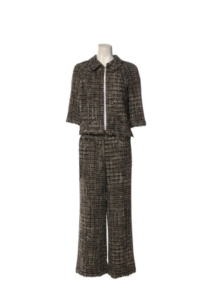 Authentic Chanel black and ivory tweed two-piece set featuring a cropped fringe-trim jacket with front patch pockets and matching cropped wide-leg trousers