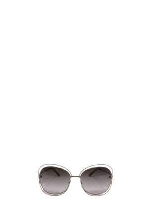 Chloé oversized sunglasses with a gold-tone metal frame, rounded geometric shape, slim temples, and grey gradient lenses.