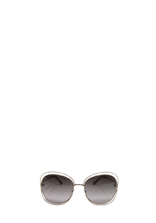 Chloé oversized sunglasses with a gold-tone metal frame, rounded geometric shape, slim temples, and grey gradient lenses.