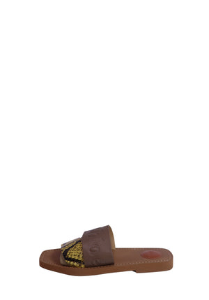 Chloé beige leather flat slide sandals featuring embossed logo straps, yellow and black python-print leather accents, cushioned leather footbeds, and a minimalist slip-on design.