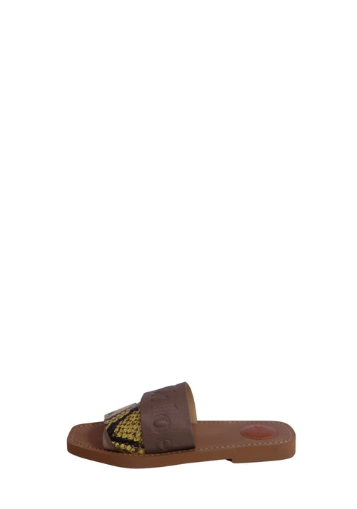 Chloé beige leather flat slide sandals featuring embossed logo straps, yellow and black python-print leather accents, cushioned leather footbeds, and a minimalist slip-on design.