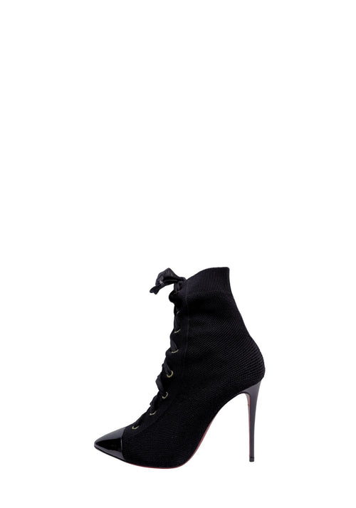 Christian Louboutin black knit ankle boots featuring a patent leather cap toe, lace-up front, stiletto heel, and signature red sole