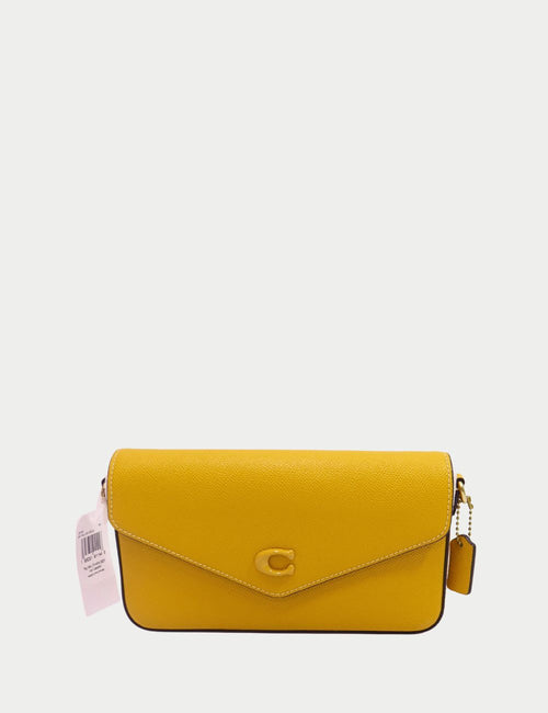 Coach mustard yellow leather crossbody bag with envelope flap, gold-tone C logo, and detachable tag charm