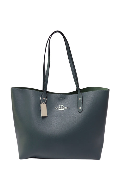 Coach dark green pebbled leather tote bag with long shoulder straps, silver-tone Coach logo and matching leather luggage tag. Spacious open-top design with a structured silhouette
