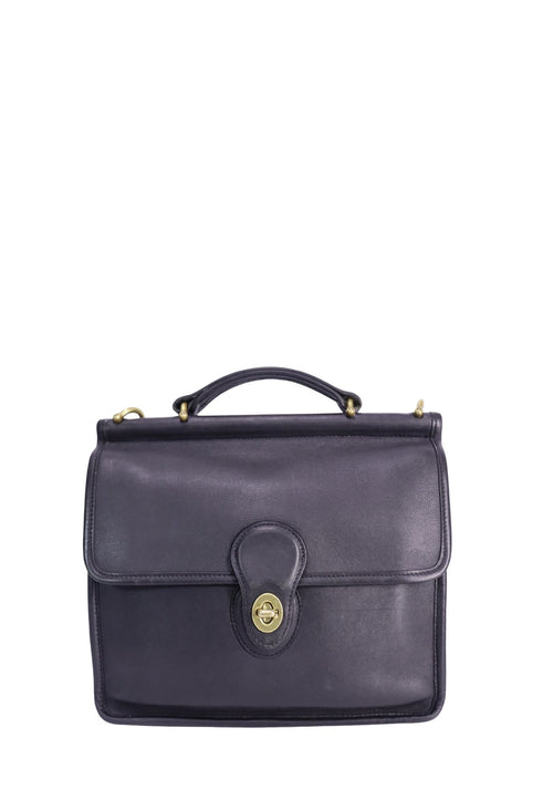 Vintage Coach Willis bag crafted in black leather featuring a structured top-handle silhouette, brass-tone turn-lock closure, flap front design, and shoulder strap attachments