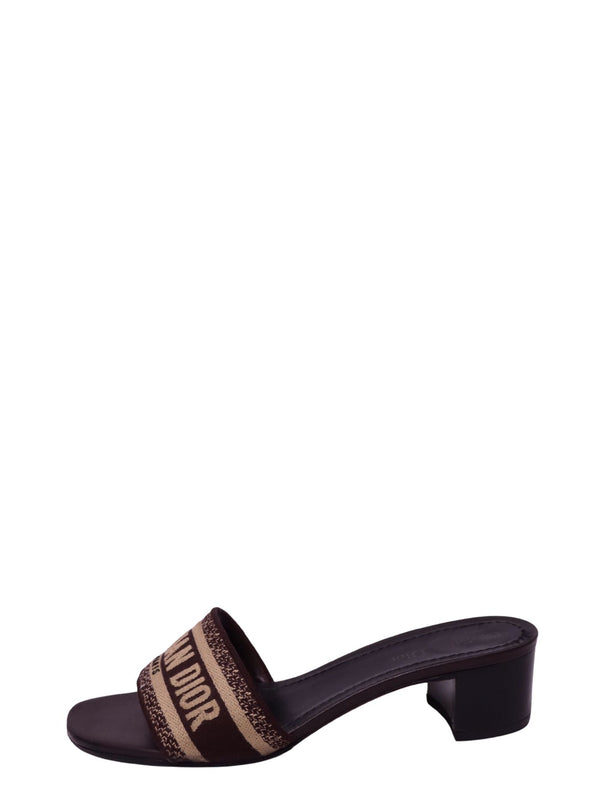 Christian Dior brown and beige heeled slide sandal featuring a wide woven Christian Dior logo strap, open toe, dark brown footbed, and mid-height block heel