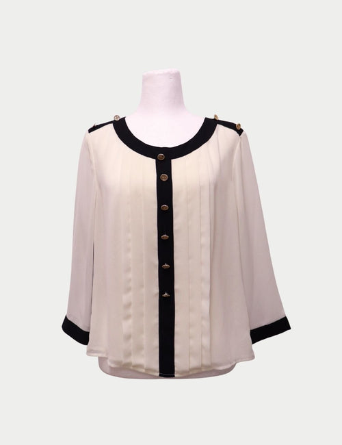 Edward Achour Paris cream blouse with black trim, gold buttons, and pleated front