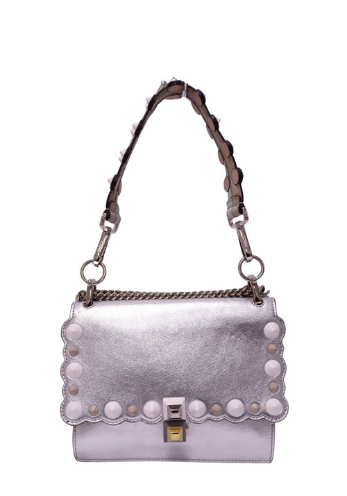 Fendi Kan I metallic silver leather shoulder bag featuring a scalloped flap, white circular stud embellishments, geometric push-lock closure, chain detailing and detachable studded strap.