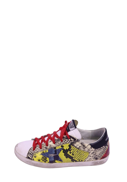 Golden Goose Superstar sneakers with snakeskin print, yellow star detail, and red laces in distressed finish