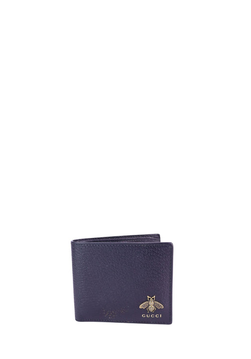Gucci textured leather bifold wallet in dark navy with gold-tone bee logo detail on the front.