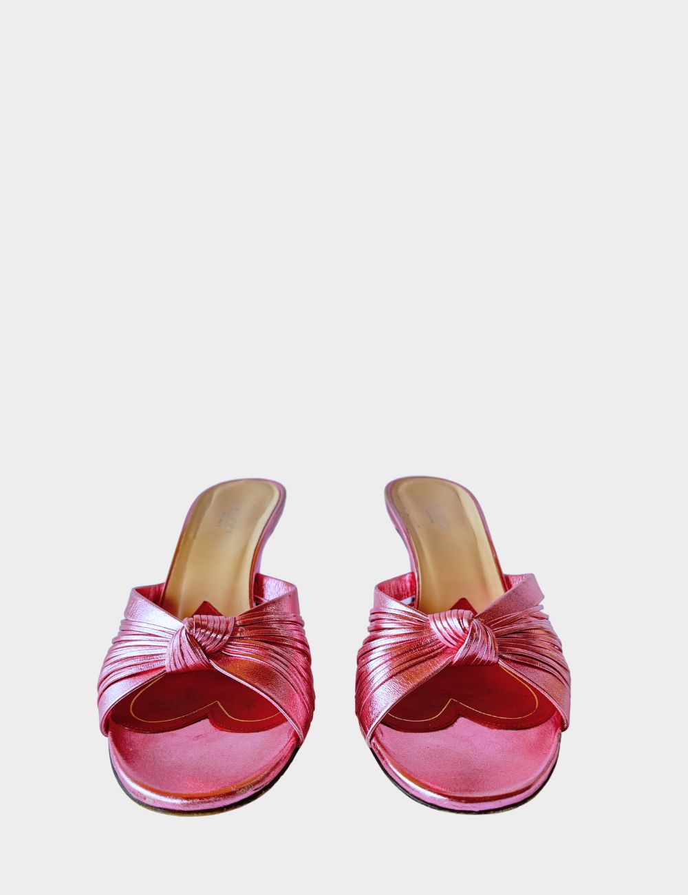 Step into feminine glamour with these Gucci metallic pink mules, designed with an elegant vintage-inspired silhouette. Featuring soft, knotted crossover straps, these slip-on heels are crafted from lustrous metallic leather that catches the light with eve Step into feminine glamour with these Gucci metallic pink mules, designed with an elegant vintage-inspired silhouette. Featuring soft, knotted crossover straps, these slip-on heels are crafted from lustrous metallic leather that catches the light with eve