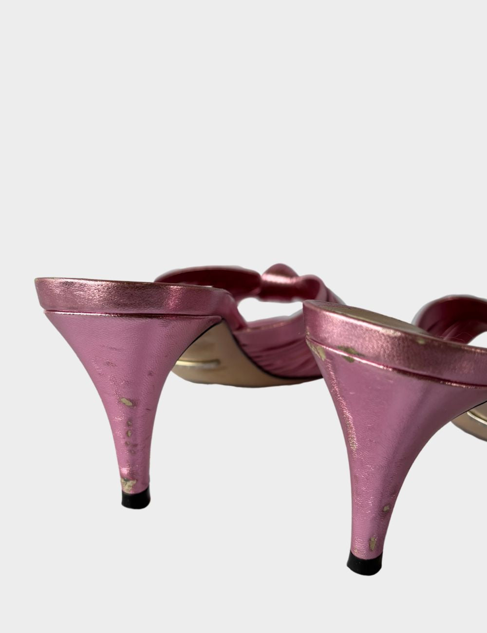 Step into feminine glamour with these Gucci metallic pink mules, designed with an elegant vintage-inspired silhouette. Featuring soft, knotted crossover straps, these slip-on heels are crafted from lustrous metallic leather that catches the light with eve Step into feminine glamour with these Gucci metallic pink mules, designed with an elegant vintage-inspired silhouette. Featuring soft, knotted crossover straps, these slip-on heels are crafted from lustrous metallic leather that catches the light with eve