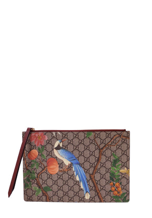 Gucci Tian wristlet pouch in beige and ebony GG Supreme monogram canvas featuring a vibrant blue bird, colorful flowers, fruit and botanical illustrations, burgundy leather wrist strap, and top zip closure
