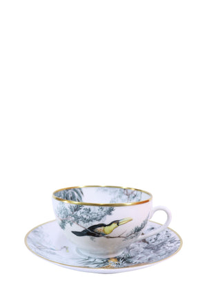 Hermès Carnets d'Équateur porcelain tea cup and matching saucer featuring exotic bird illustrations, tropical foliage motifs, and elegant gold-rim detailing