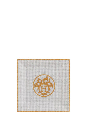 Hermès Mosaique au 24 gold porcelain square plate with mosaic pattern and central Hermès logo in white and gold tones.
