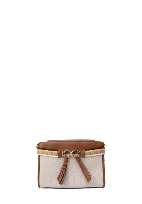 Kate Spade canvas and leather crossbody bag featuring a cream woven body, tan leather trim, decorative tassel accents, striped braided detailing, and gold-tone hardware