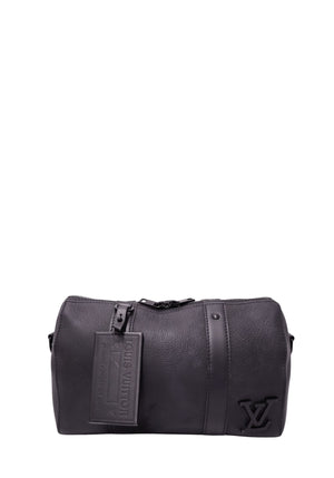 Louis Vuitton black grained leather Keepall-style bag with raised tonal LV logo, embossed luggage tag, vertical leather bands and black hardware