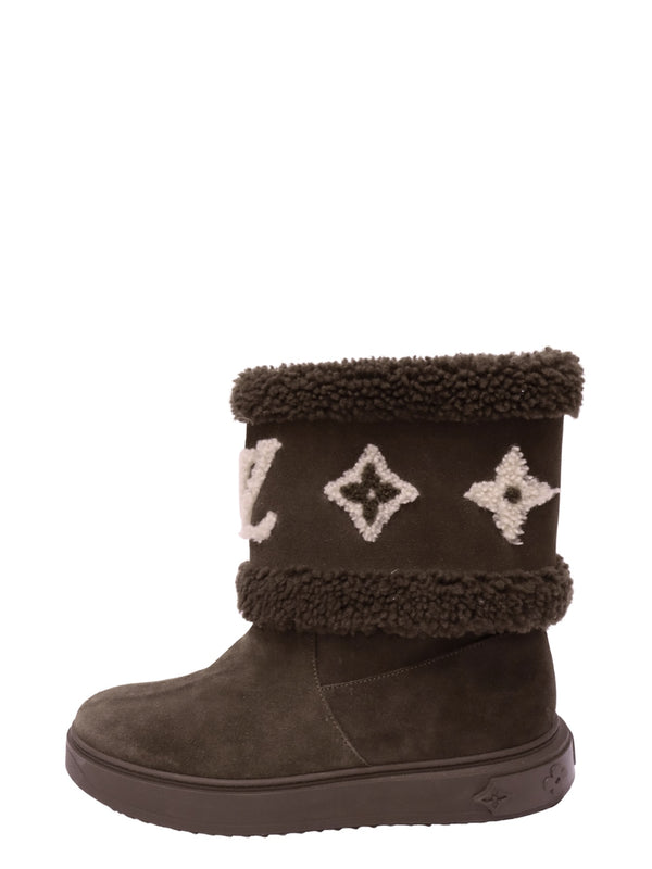 Louis Vuitton chocolate brown suede winter boot featuring cream LV Monogram embroidery, plush brown shearling-style trim, rounded toe, and chunky rubber sole with embossed Monogram flowers