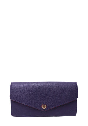 Louis Vuitton Sarah Wallet in navy Monogram Empreinte leather with red trim and gold-tone snap closure.