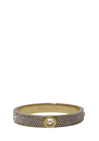 Michael Kors gold-tone oval bangle bracelet embellished with multiple rows of clear pavé crystals and a circular MK logo medallion