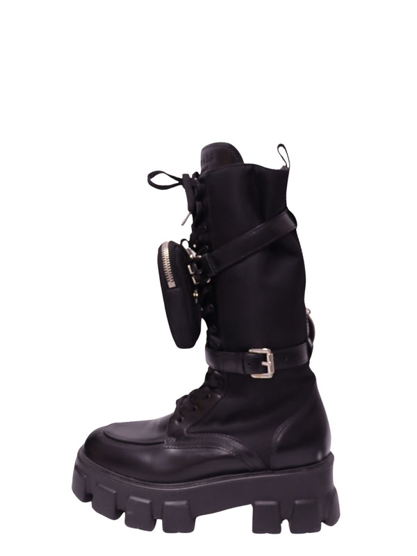 Prada black Monolith knee-high combat boot with leather and nylon upper, chunky platform lug sole, lace-up front, buckle straps and detachable zippered pouch