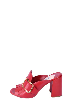 Prada red leather mule heels with fringe detailing, oversized gold-tone buckle accents, and block heels.