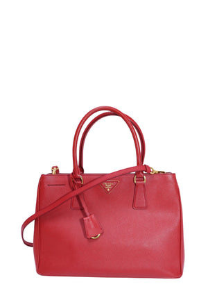 Authentic Prada Saffiano Lux medium red leather double zip tote bag with gold-tone hardware, dual top handles, detachable shoulder strap, and signature Prada triangle logo.