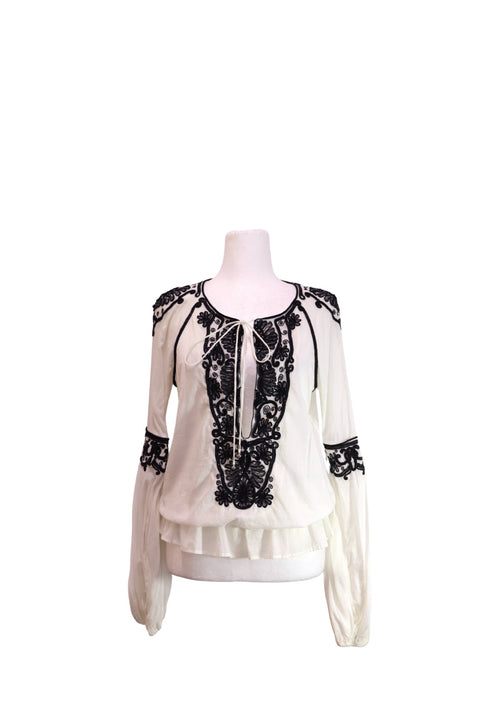 Roberto Cavalli white long-sleeve blouse with black floral embroidery, tie-neck detail, and relaxed bohemian silhouette.