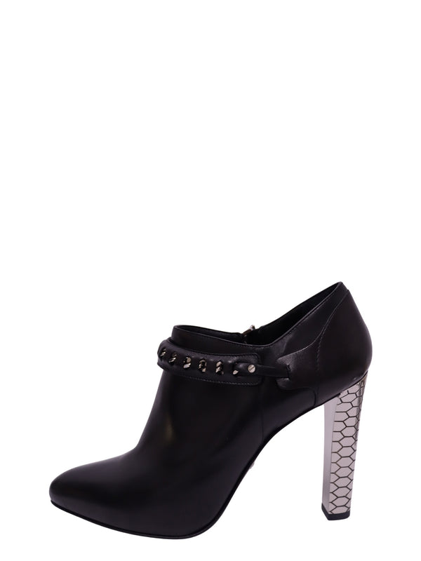 Roberto Cavalli black leather heeled ankle boot featuring a rounded almond toe, silver-tone studded strap and high metallic block heel with a hexagonal honeycomb pattern.