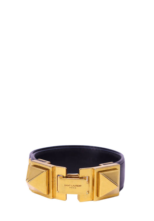 Saint Laurent black leather cuff bangle with gold-tone geometric hardware and engraved logo detail.