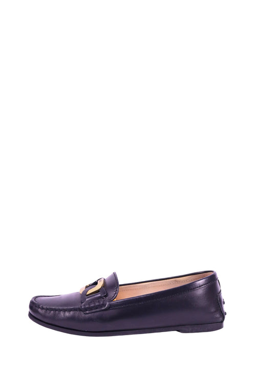 Tod’s black leather loafers with gold hardware detail on front