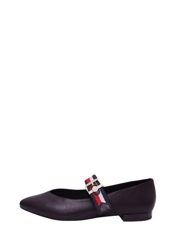 Tommy Hilfiger black leather Mary Jane flats with signature red, white, and navy webbing strap, gold-tone buckle, and pointed toe
