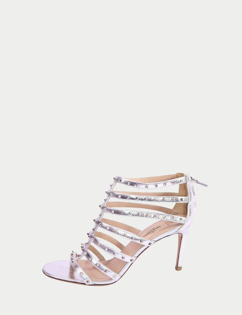 Silver strappy high-heel sandals by Valentino featuring studded cage-style straps, open toe, ankle zip closure, and slim stiletto heel
