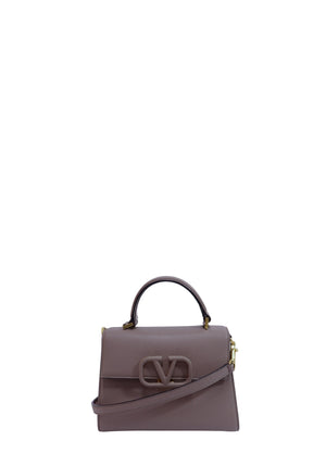Valentino Garavani dark mauve grained leather top handle bag with tonal VLogo closure, gold-tone hardware, and detachable shoulder strap.