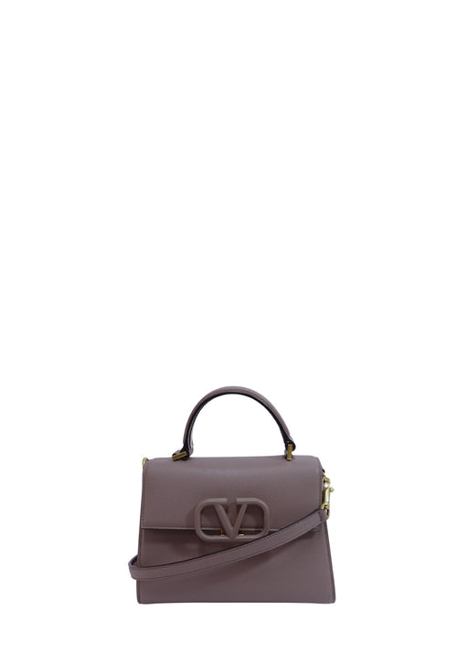 Valentino Garavani dark mauve grained leather top handle bag with tonal VLogo closure, gold-tone hardware, and detachable shoulder strap.