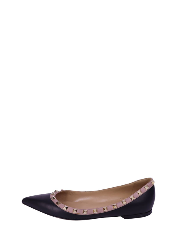 Valentino Garavani black pointed-toe ballet flats with blush pink trim and signature gold-tone Rockstud detailing.